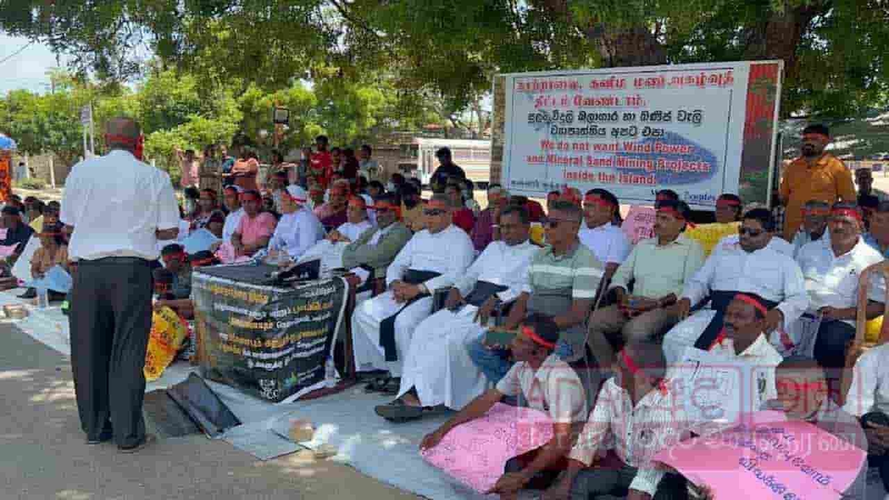 சிவப்பு நிற தலைப்பட்டியுடன் போராட்டத்தில் ஈடுபட்ட மக்கள்